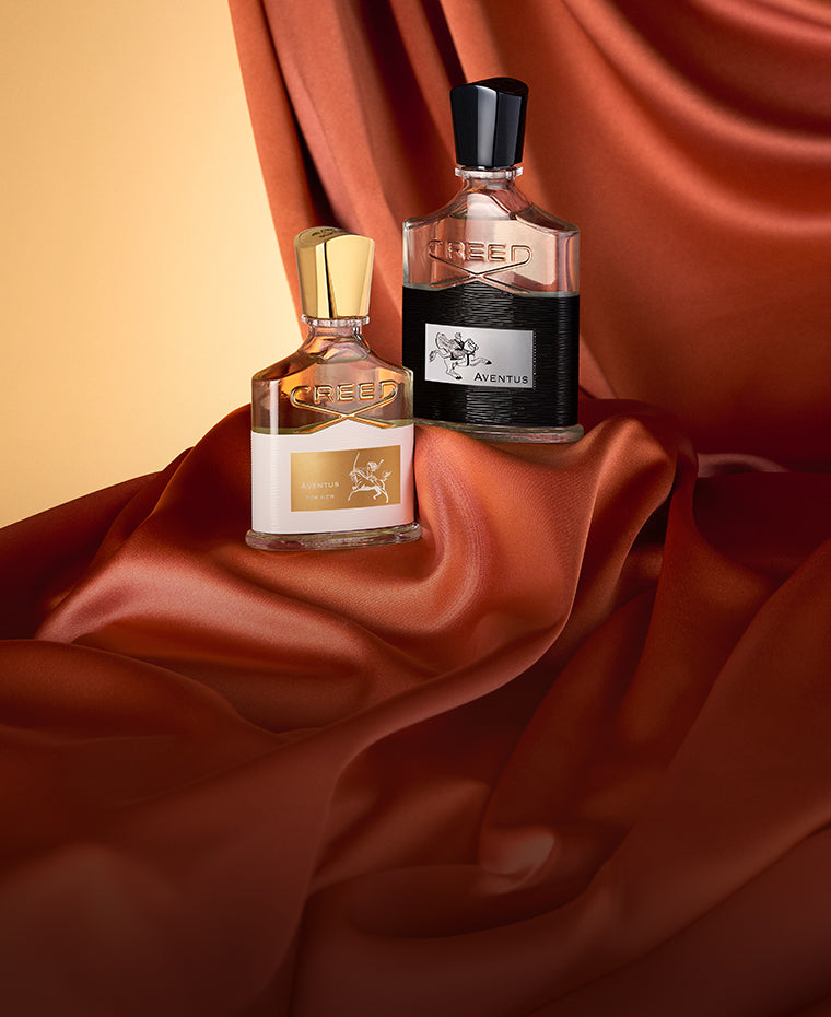 Aventus and Aventus For Her with orange curtain and yellow background.